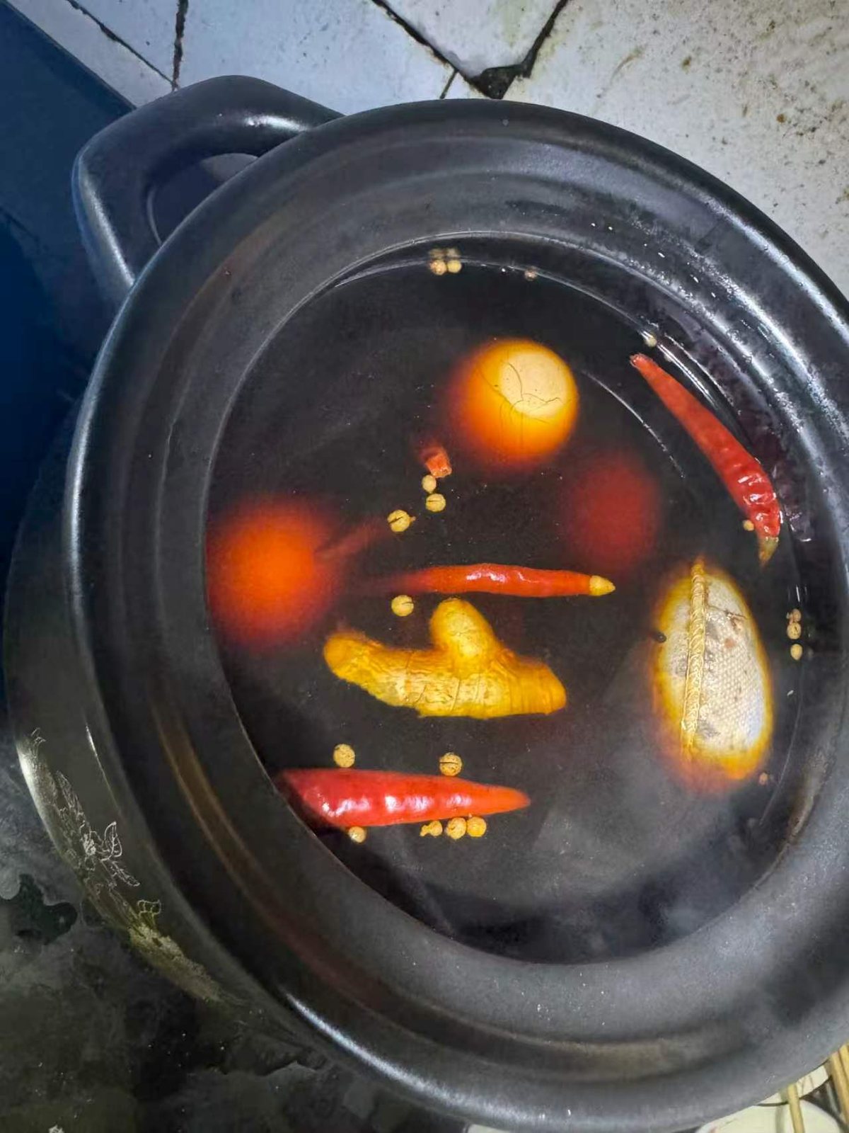 砂锅浸泡,汤面浮着辣椒、姜、料包、白蔻 如何做好一锅茶叶卤蛋(图9)